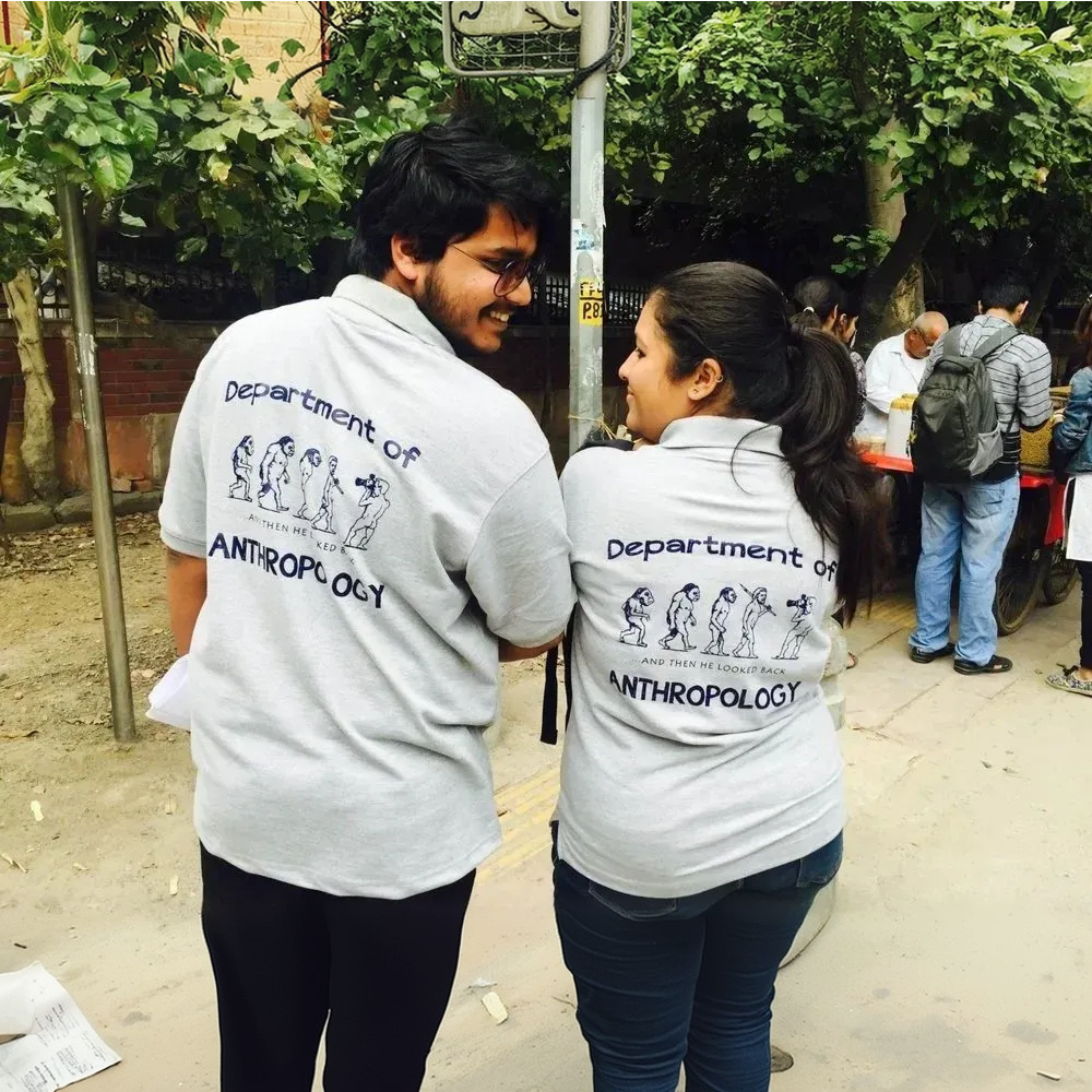 Two people wearing 'Department of Anthropology' shirts standing outdoors.