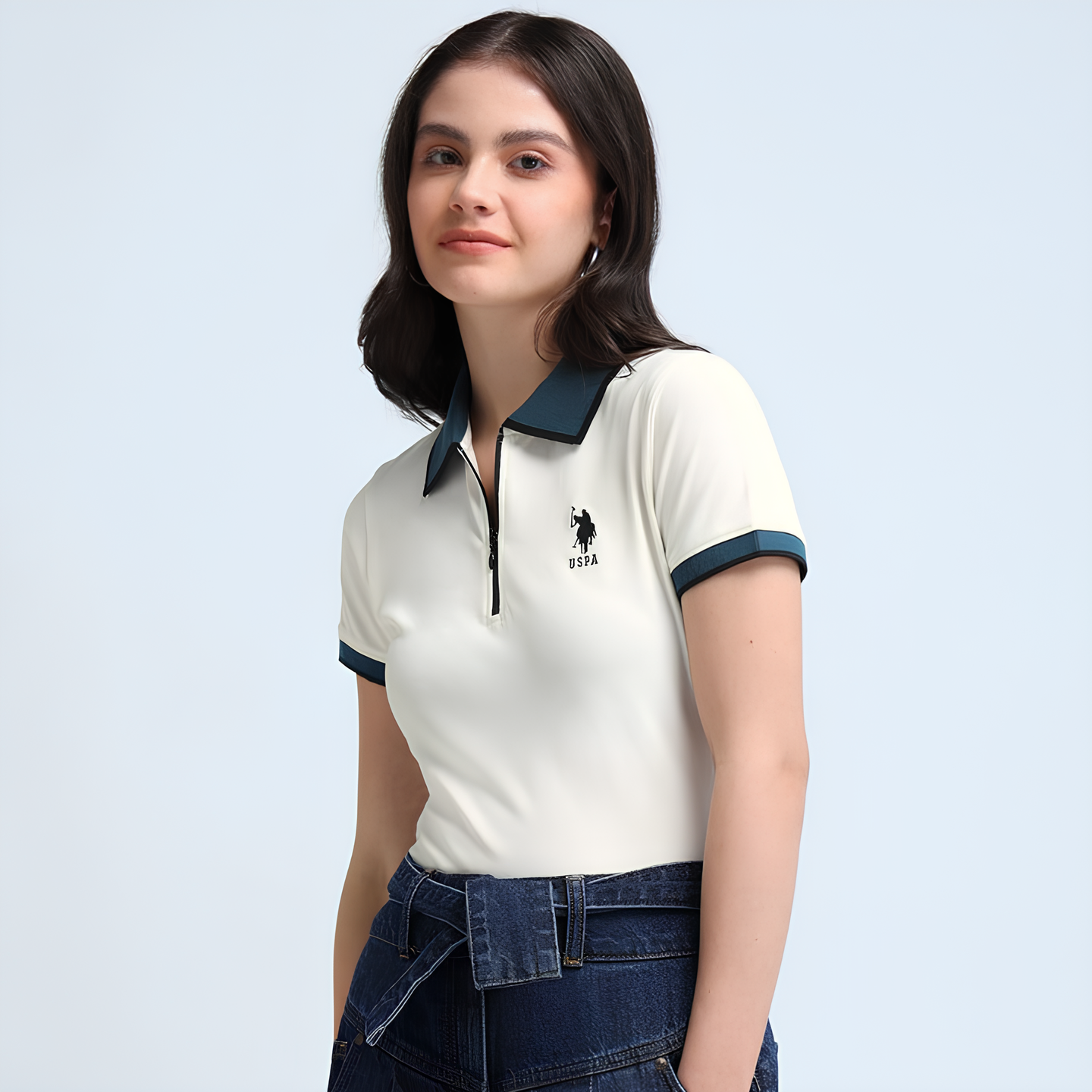 Woman wearing a white polo shirt with blue accents and a logo on a light gray background