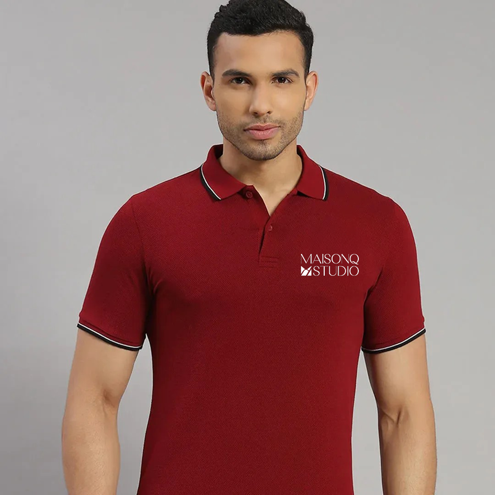 Man wearing a red polo shirt with 'MAISONQ STUDIO' logo on a gray background