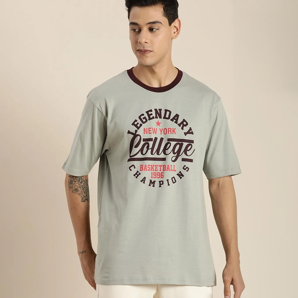 Man wearing a light gray t-shirt with text design on a beige background