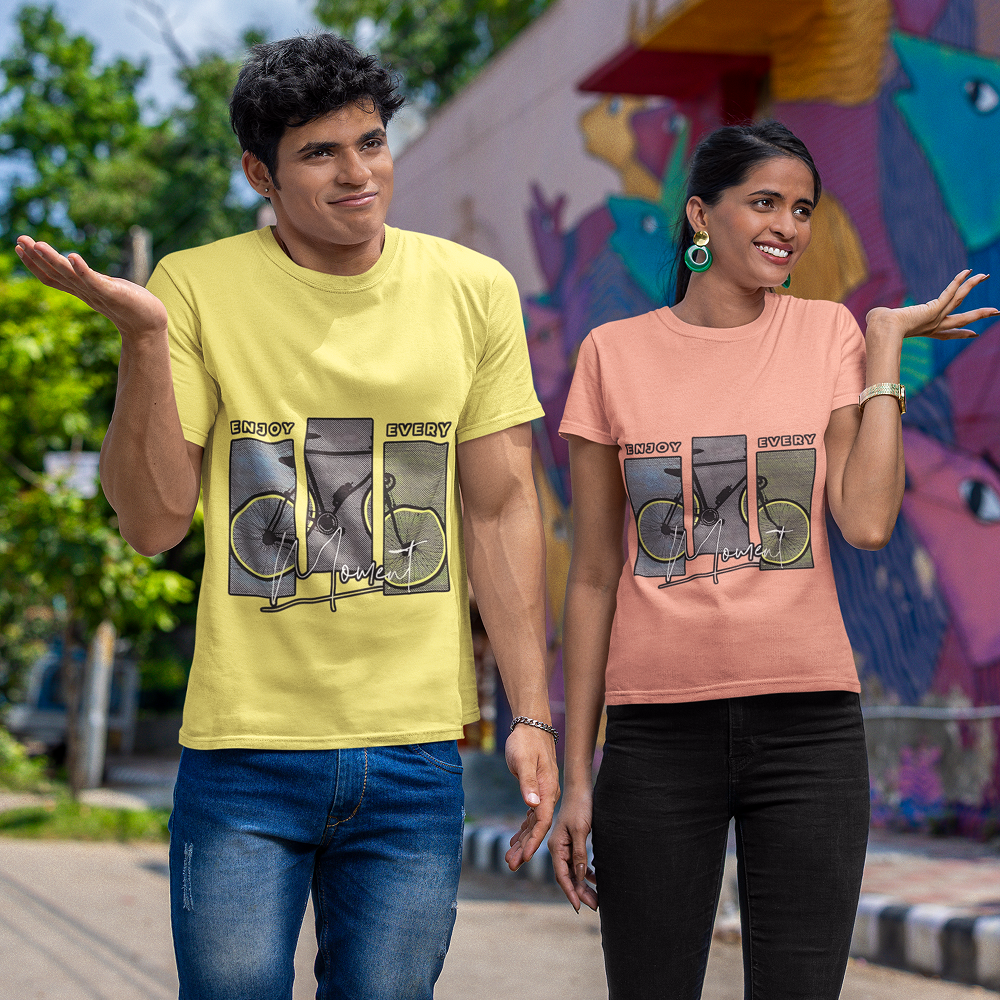 Two people wearing t-shirts with bicycle graphic designs in front of a colorful mural.