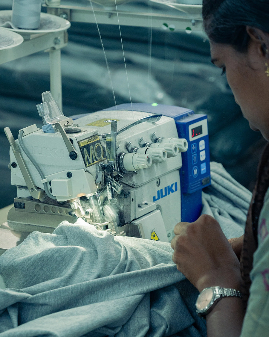 Person operating a Juki sewing machine in an industrial setting