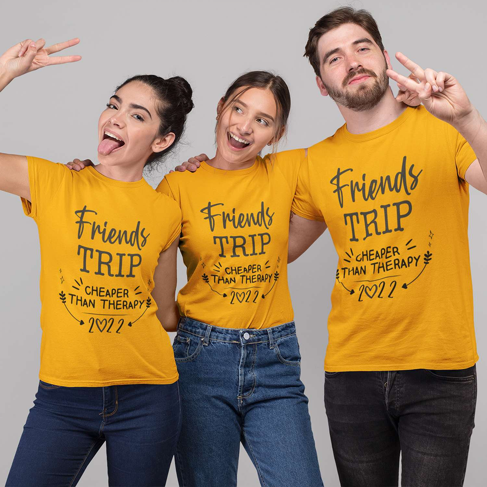 Three friends wearing yellow 'Friends Trip' t-shirts against a gray background
